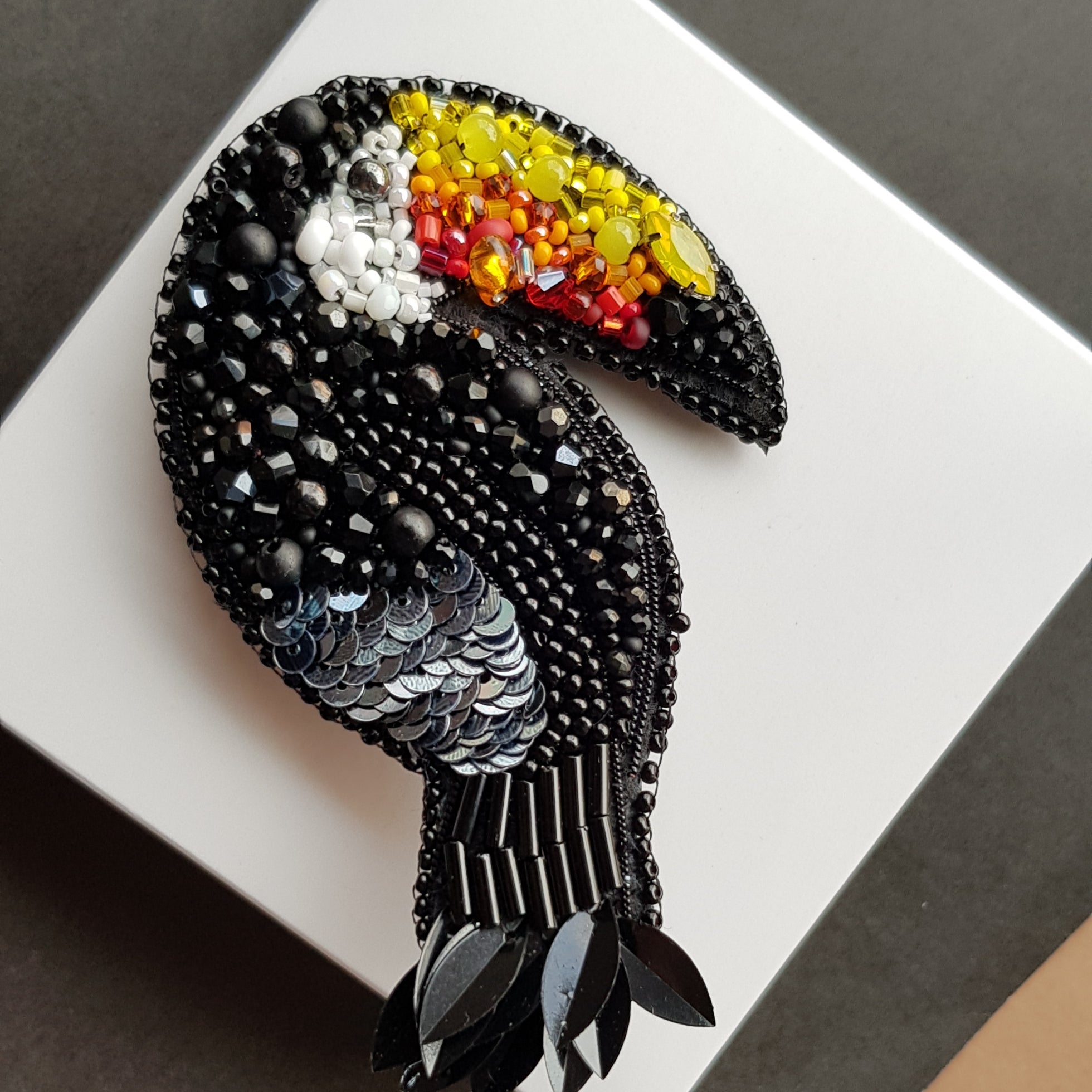 Black toucan beaded brooch hand embroidered with colorful yellow orange red beak, black beads, sequins, and crystal details