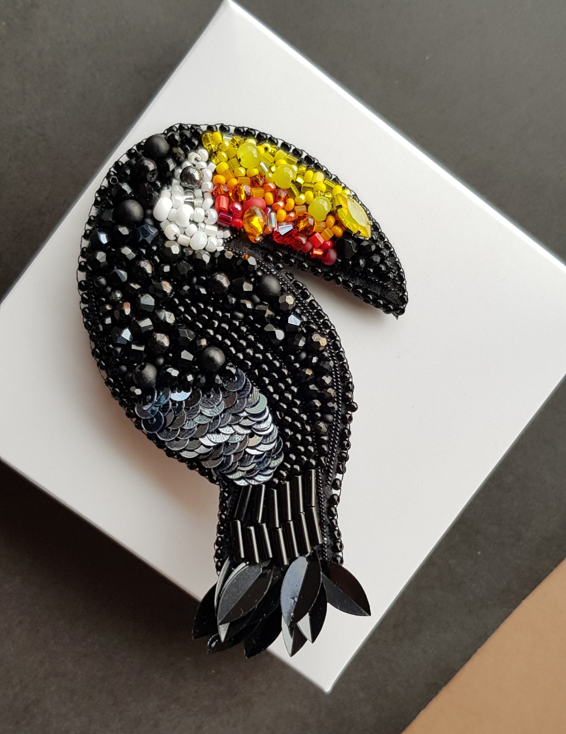 Black toucan beaded brooch hand embroidered with colorful yellow orange red beak, black beads, sequins, and crystal details