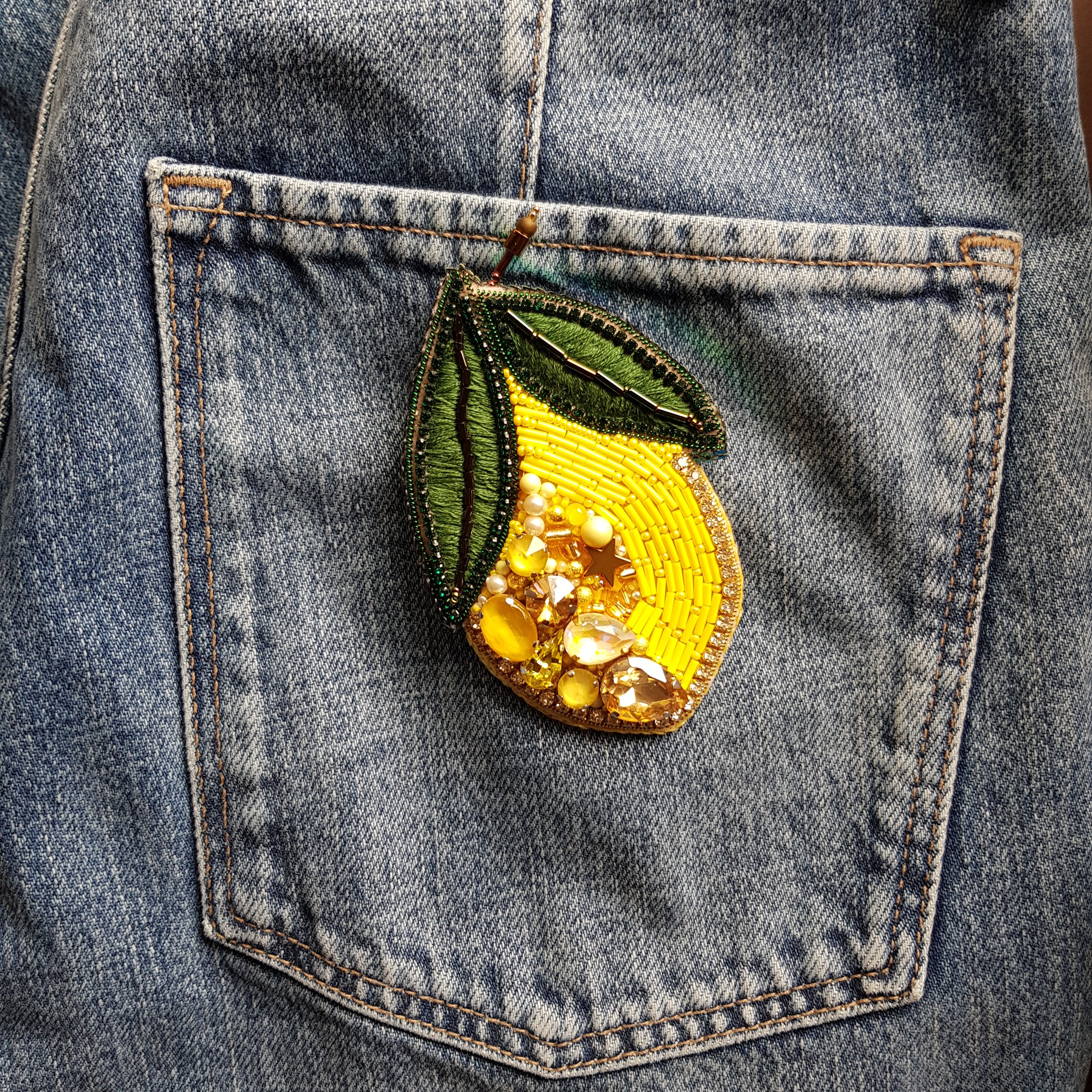 Denim pocket with a decorative lemon patch and 'Max Mara' brand label.