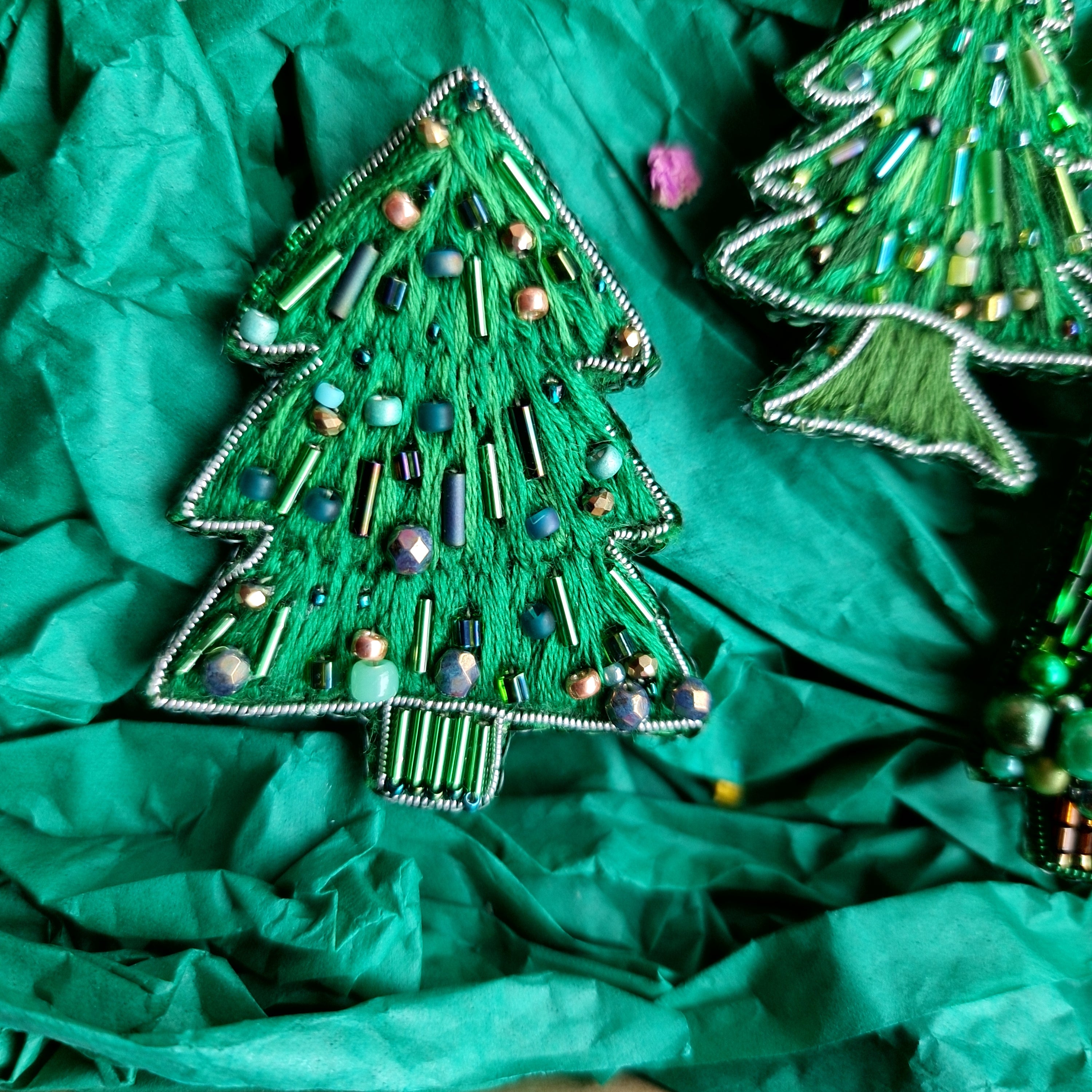 Decorative Christmas tree ornaments on green tissue paper