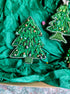 Decorative Christmas tree ornaments on green tissue paper