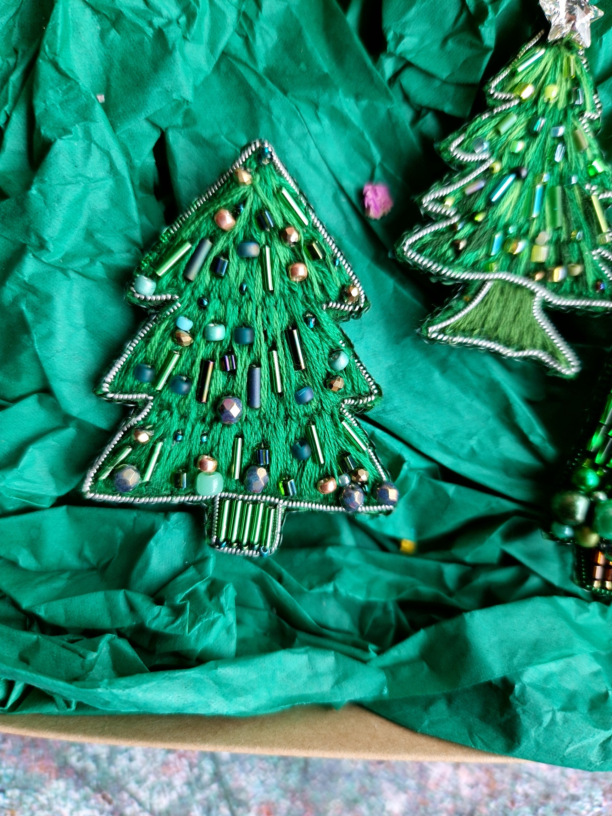 Decorative Christmas tree ornaments on green tissue paper