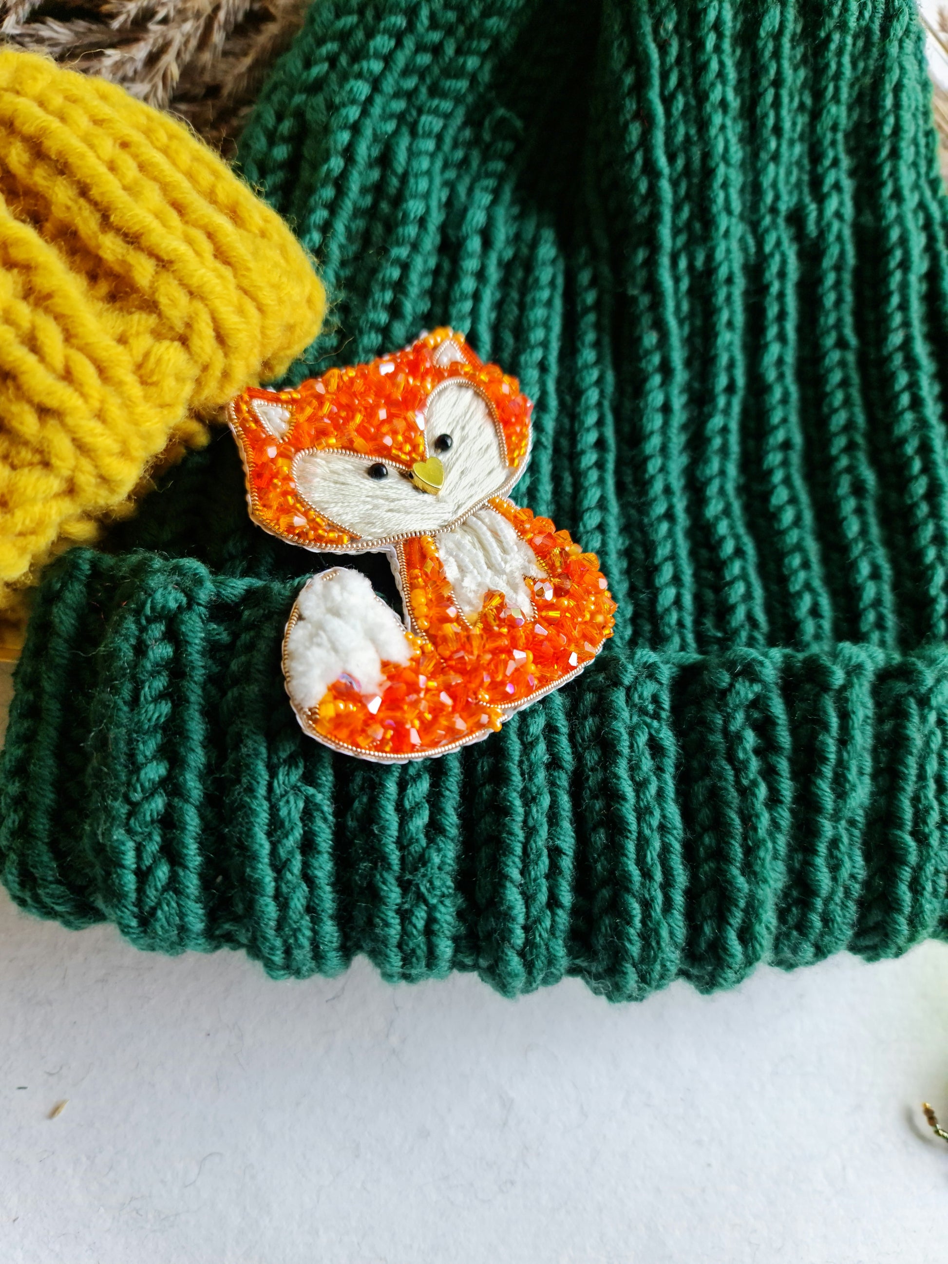 Handmade fox beaded brooch in orange tones with fluffy white tail detail and embroidered face