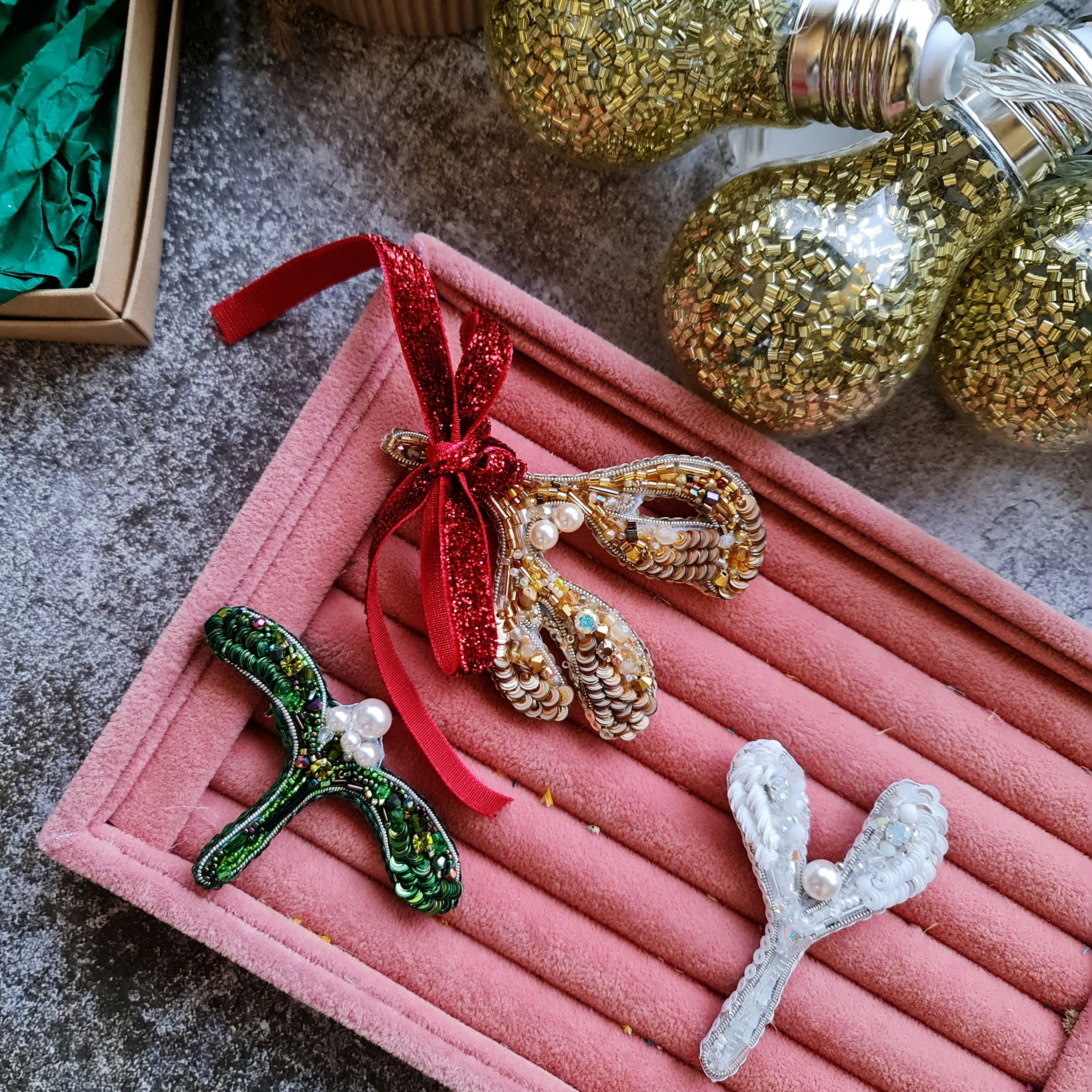 Handmade mistletoe brooch collection in gold, green and white, embroidered with beads, sequins, crystals and pearls, festive Christmas accessory.