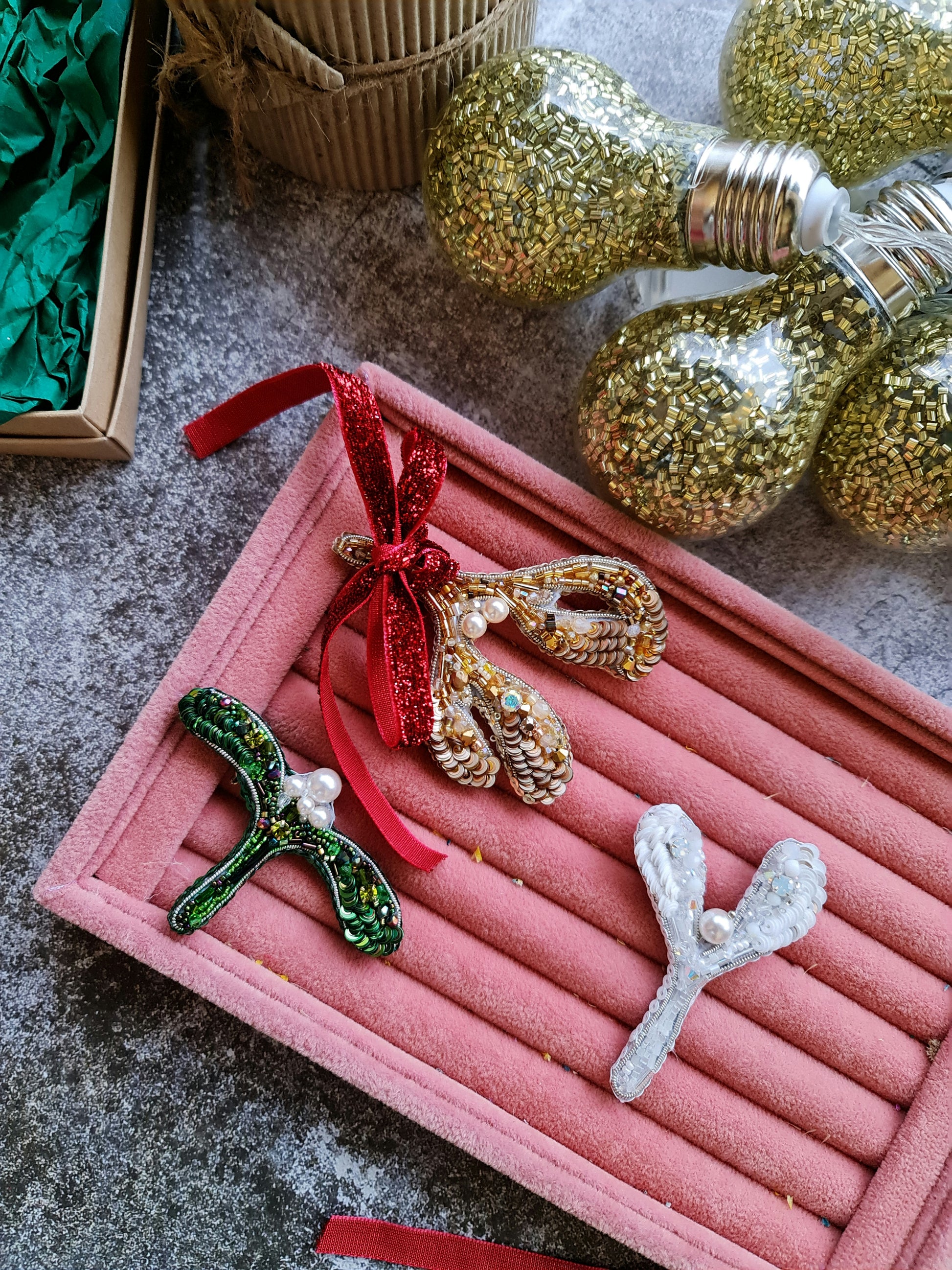 Handmade mistletoe brooch collection in gold, green and white, embroidered with beads, sequins, crystals and pearls, festive Christmas accessory.