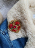 Close-up of a handcrafted embroidered brooch with delicate beadwork, showcasing fine details and high-quality craftsmanship