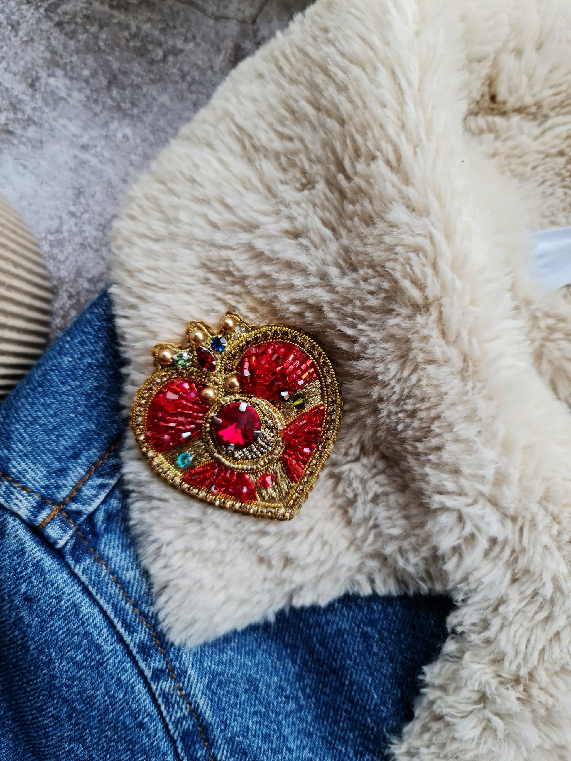 Close-up of a handcrafted embroidered brooch with delicate beadwork, showcasing fine details and high-quality craftsmanship