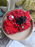 Red beaded flower brooch on a textured surface