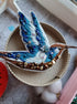 Blue hummingbird beaded brooch hand embroidered with blue white and brown thread, crystals, beads, and sparkling bird details