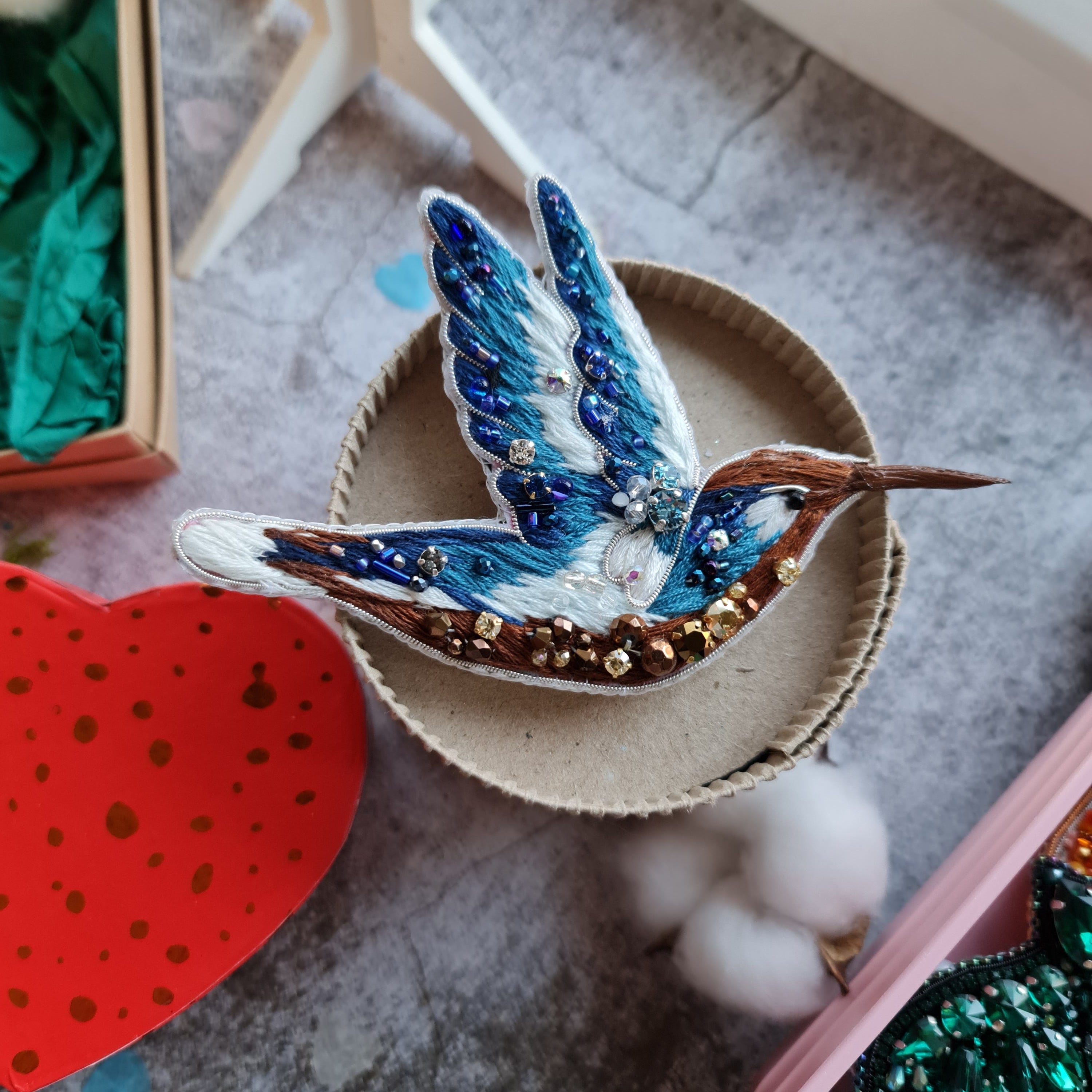 Blue hummingbird beaded brooch hand embroidered with blue white and brown thread, crystals, beads, and sparkling bird details