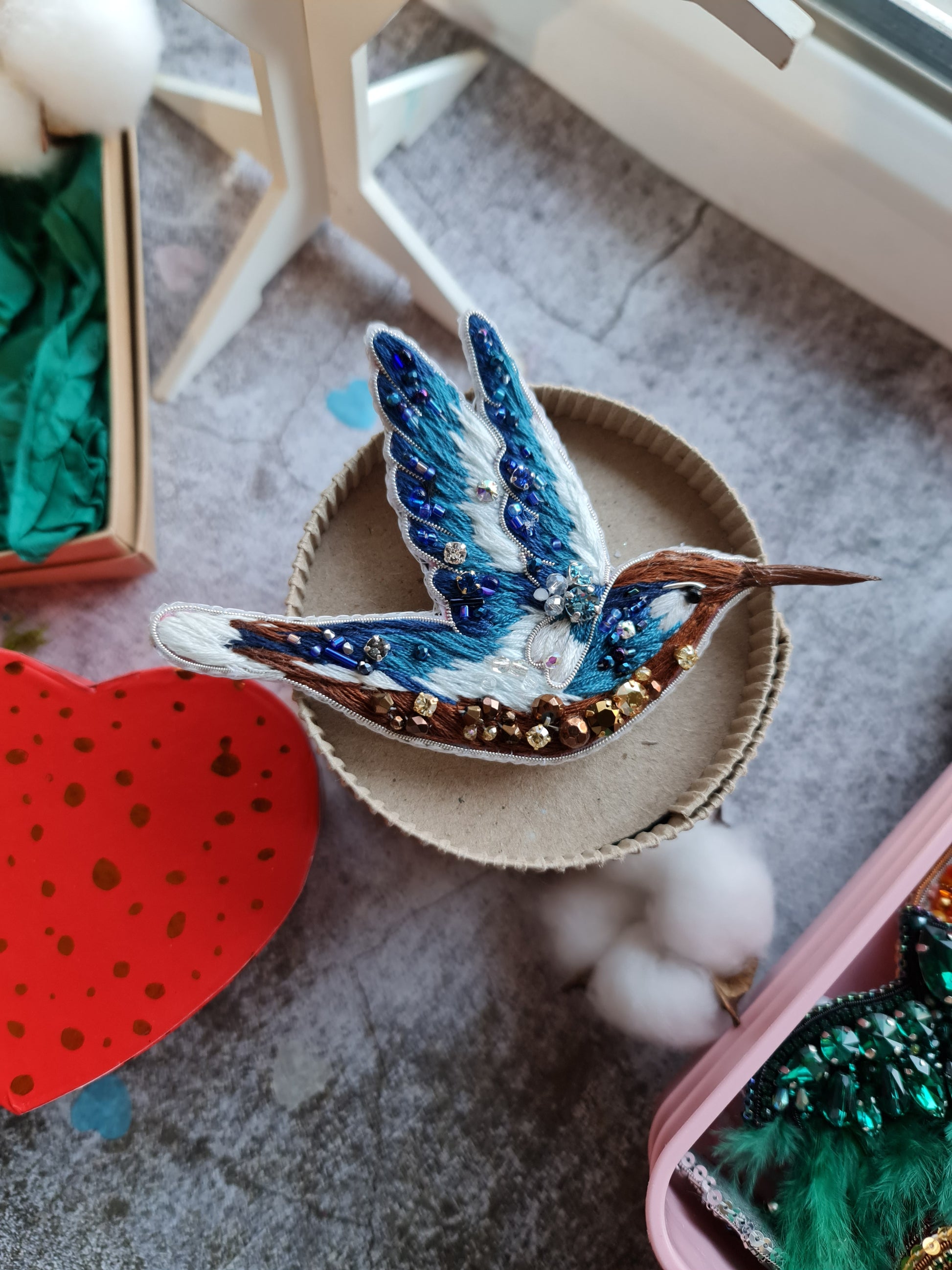 Blue hummingbird beaded brooch hand embroidered with blue white and brown thread, crystals, beads, and sparkling bird details