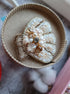 Decorative brooch with pearls and gold accents on a textured surface