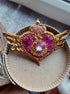 Close-up of a handmade Cosmic Heart Compact Brooch showing detailed beadwork and embroidered patterns on a celestial heart motif.