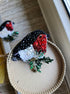 Bullfinch beaded brooch hand embroidered with red, black, white, and green beads, crystals, sequins, and winter bird details