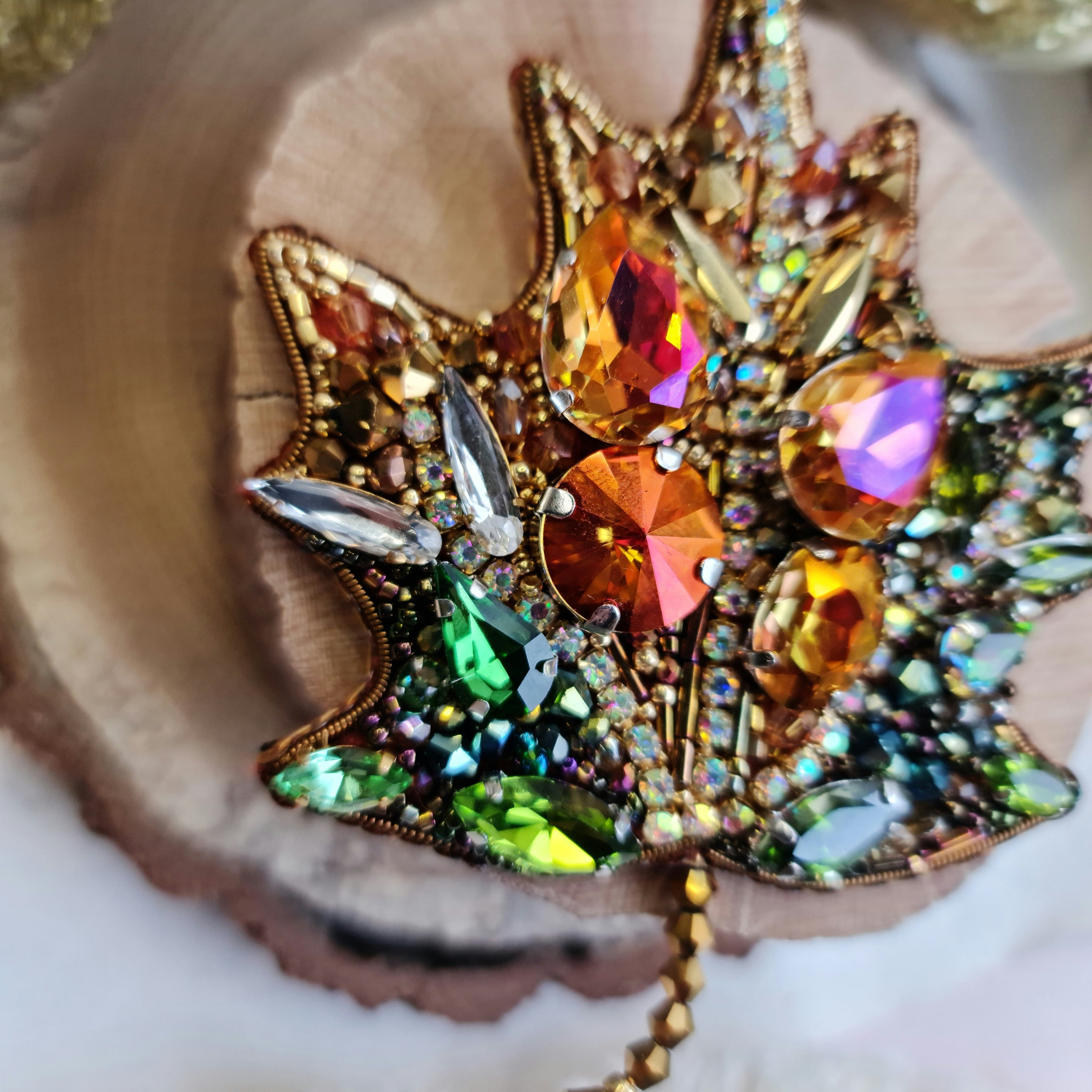 Decorative brooch with colorful gemstones on a wooden surface
