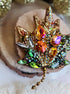 Decorative brooch with colorful gemstones on a wooden surface