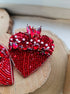 Handmade red heart beaded brooch with red beads, crystals and sequins, 6 × 6 cm, shown as a statement jewelry accessory.