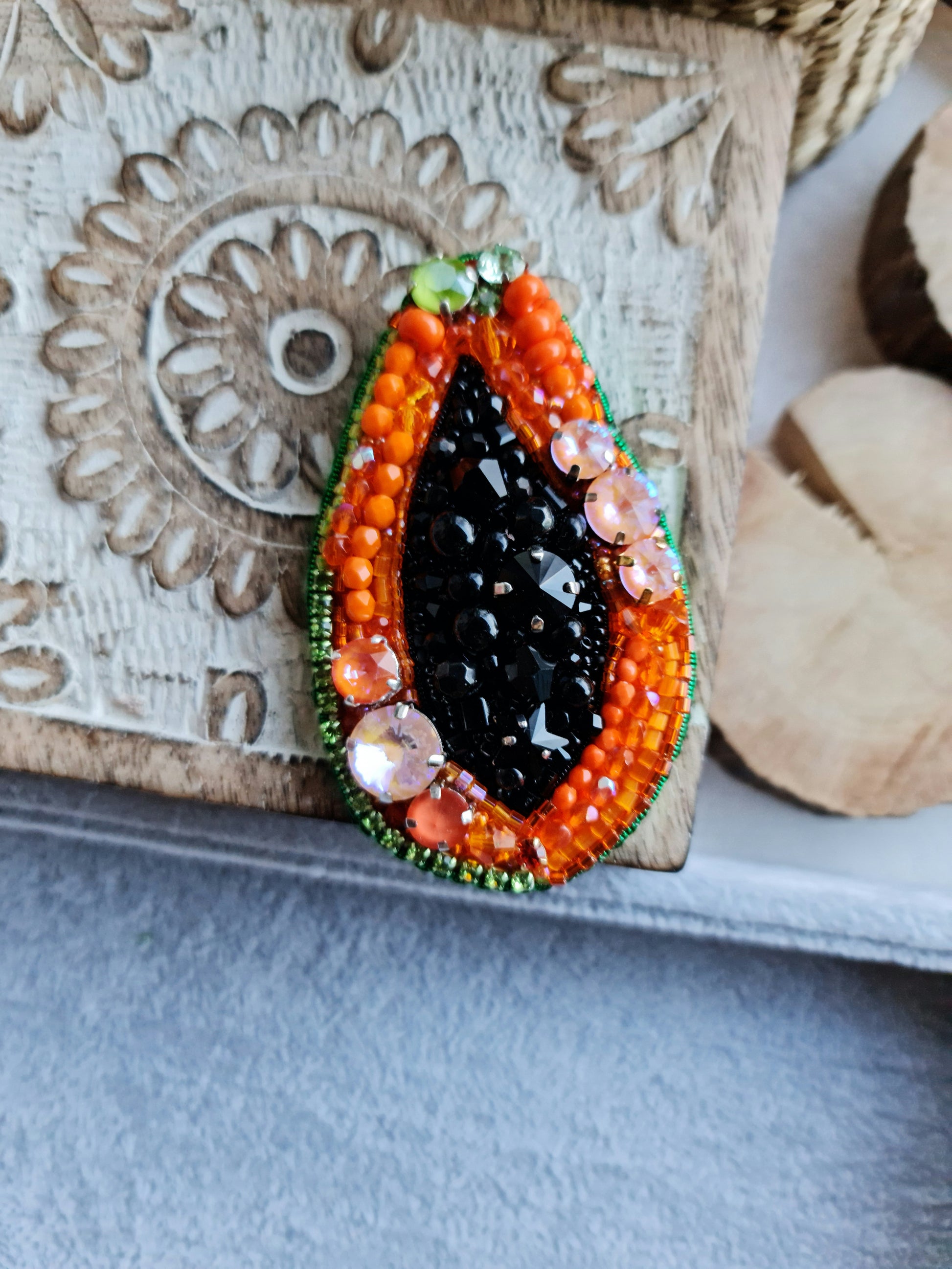 Papaya beaded brooch hand embroidered with orange beads black seed details green edge and sparkling crystals