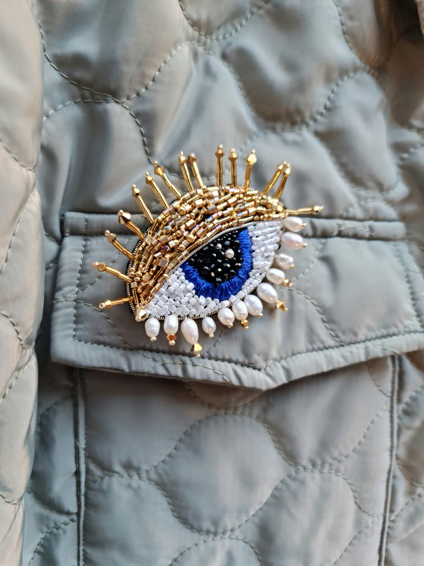 Model wearing the Enchanting Gaze Eye Brooch, an elegant accessory that adds a touch of mystique and sophistication to any outfit.