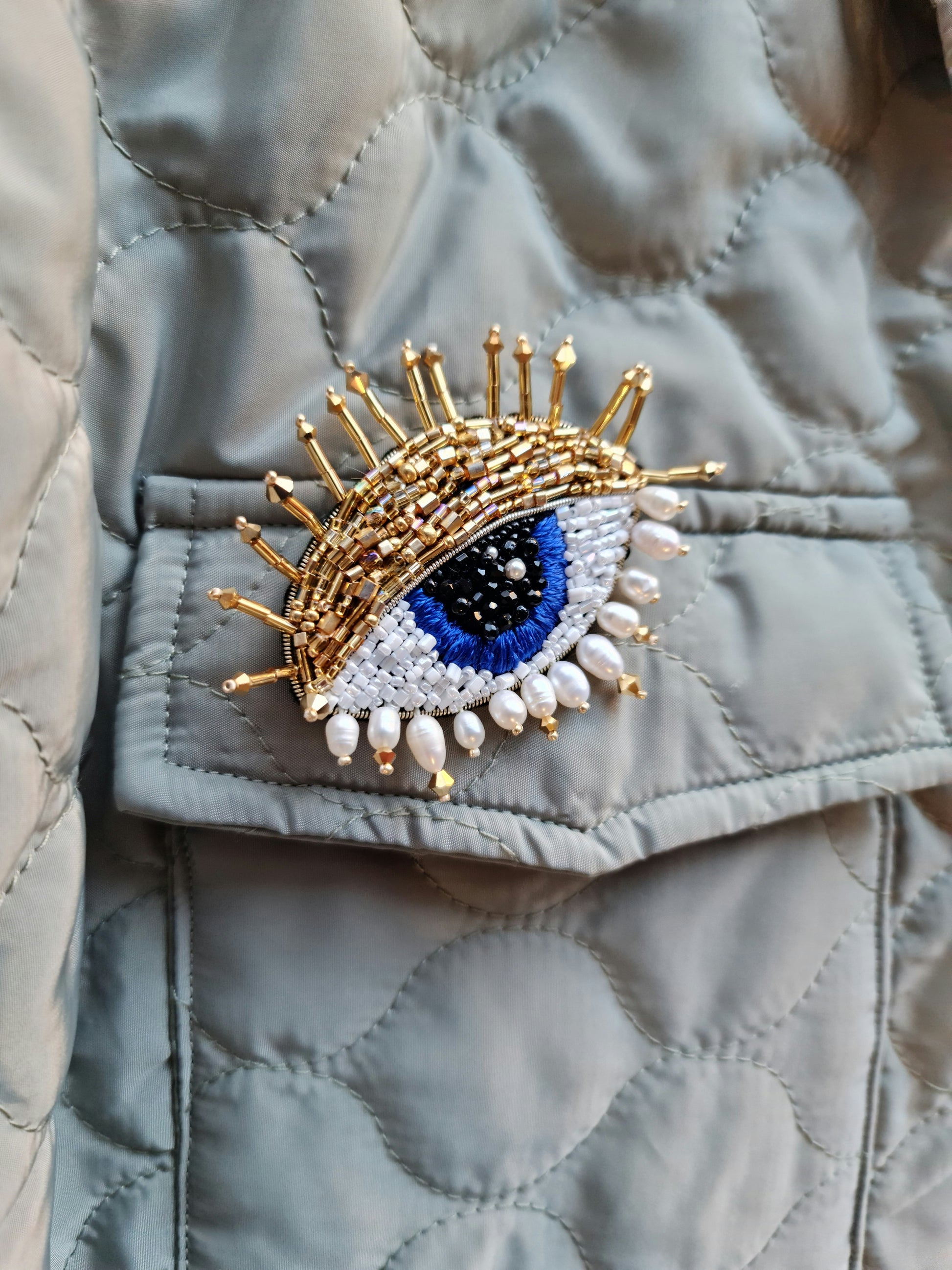 Model wearing the Enchanting Gaze Eye Brooch, an elegant accessory that adds a touch of mystique and sophistication to any outfit.