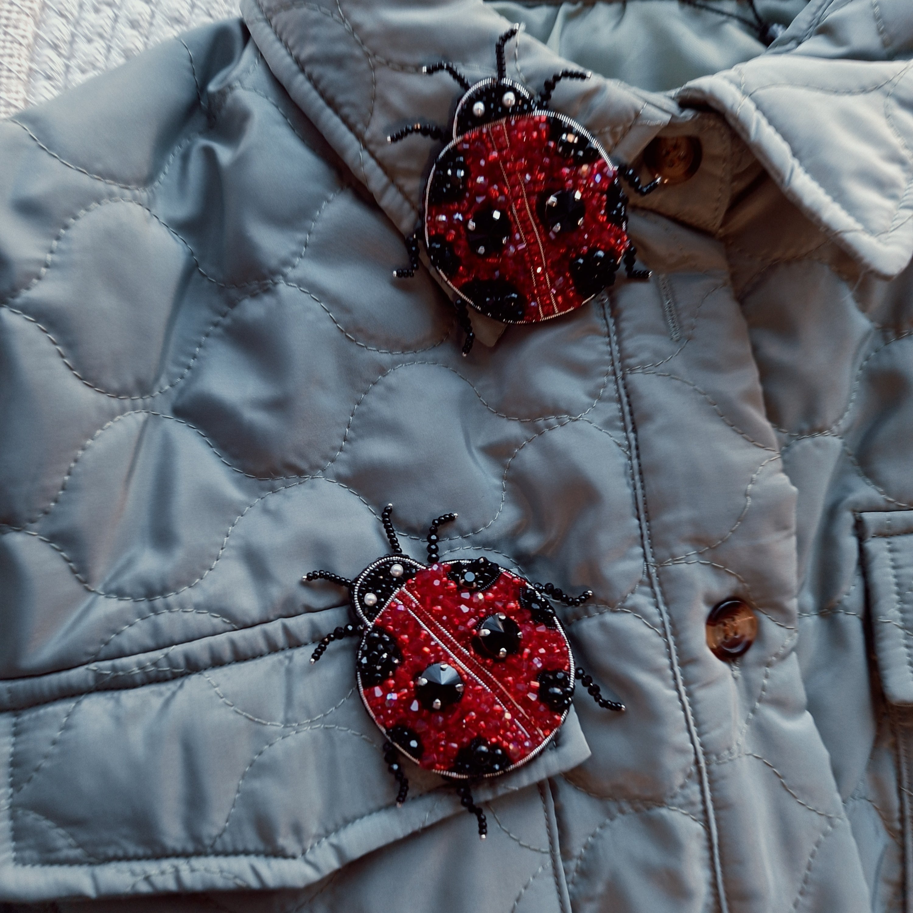 Model wearing the charming ladybug pin brooch as a statement accessory, highlighting its colorful, handcrafted design and unique appeal.