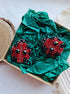 Close-up view of the intricate details on a ladybug brooch, showcasing vibrant embroidery with glass beads, crystals, and plastic beads secured on felt