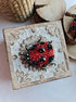 Close-up view of the intricate details on a ladybug brooch, showcasing vibrant embroidery with glass beads, crystals, and plastic beads secured on felt