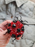 Close-up view of the intricate details on a ladybug brooch, showcasing vibrant embroidery with glass beads, crystals, and plastic beads secured on felt