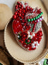 Decorative heart with red, green, and white embellishments on a textured surface
