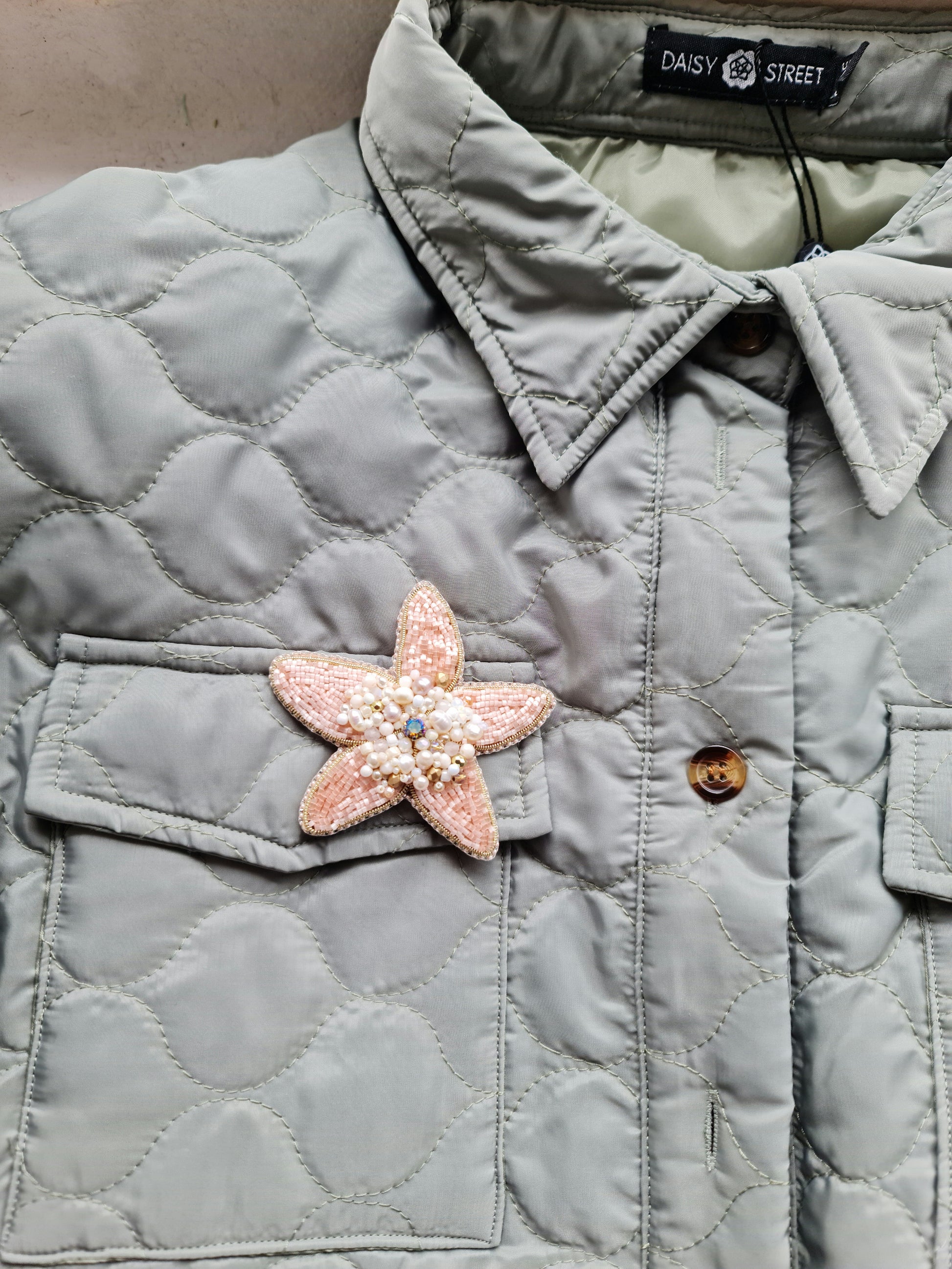 Close-up of the Stellar Seas Starfish Brooch showcasing detailed beadwork and embroidery with delicate Japanese beads, crystals, and pearls on a starfish design.