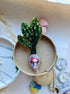 Handmade radish beaded brooch with green leaves, a pink crystal center, and sparkling embroidered details