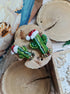 Beaded cactus brooch on a wooden surface