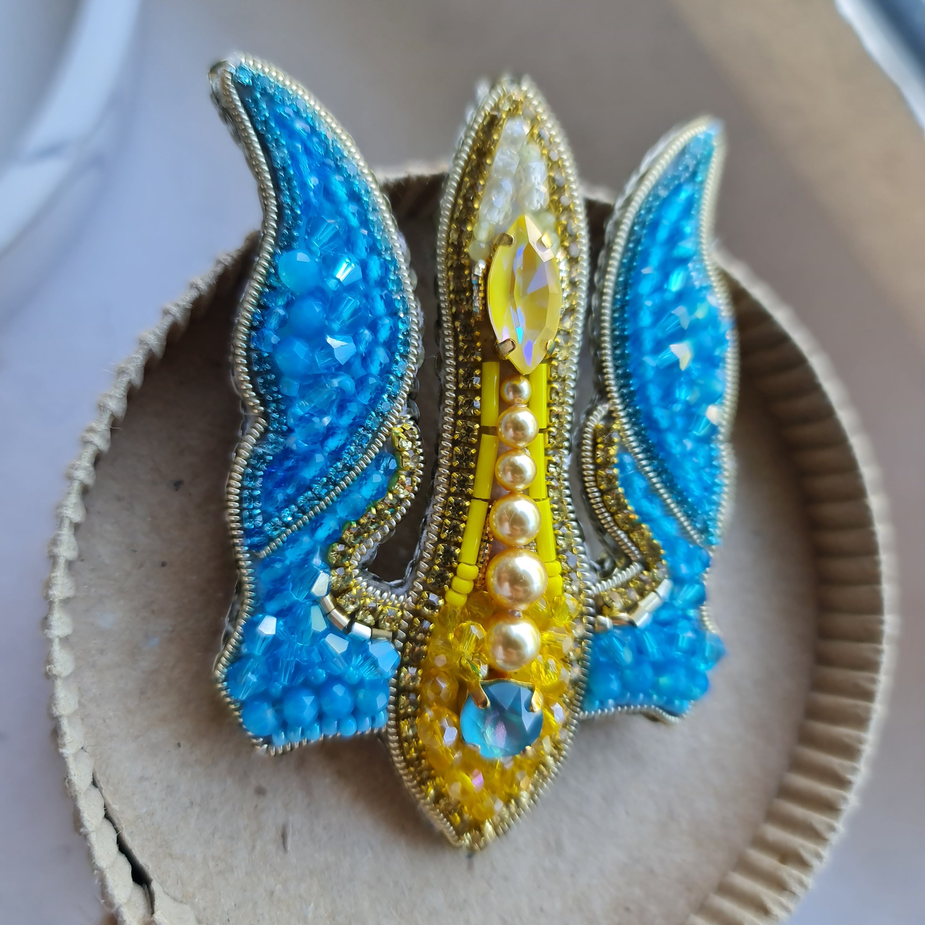 Blue and yellow trident beaded brooch hand embroidered with crystals, pearls, glass beads, and sparkling Ukraine-inspired details