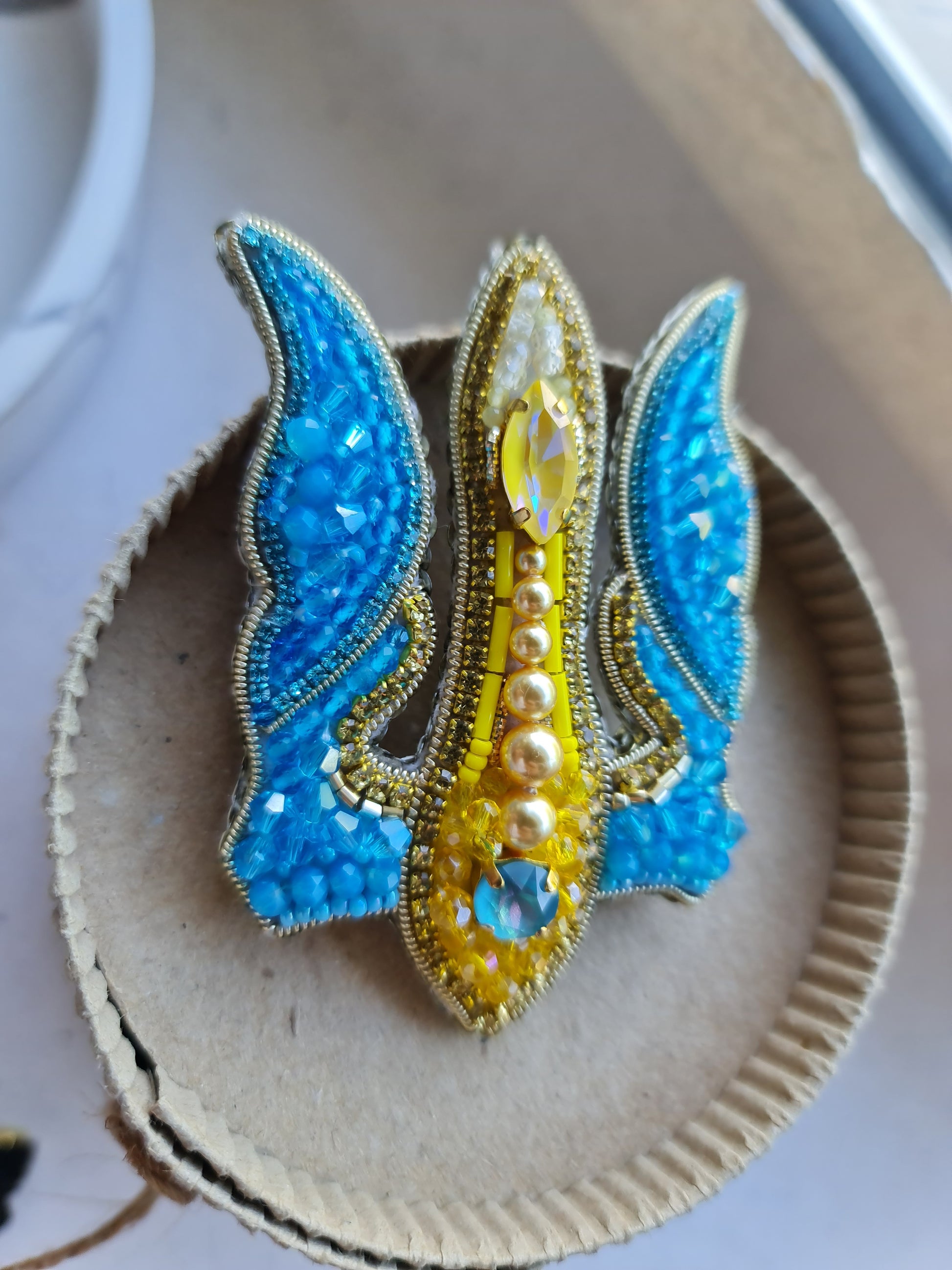 Blue and yellow trident beaded brooch hand embroidered with crystals, pearls, glass beads, and sparkling Ukraine-inspired details