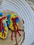 Anatomical heart beaded brooch hand embroidered with blue yellow and red beads, crystals, and sparkling chain details
