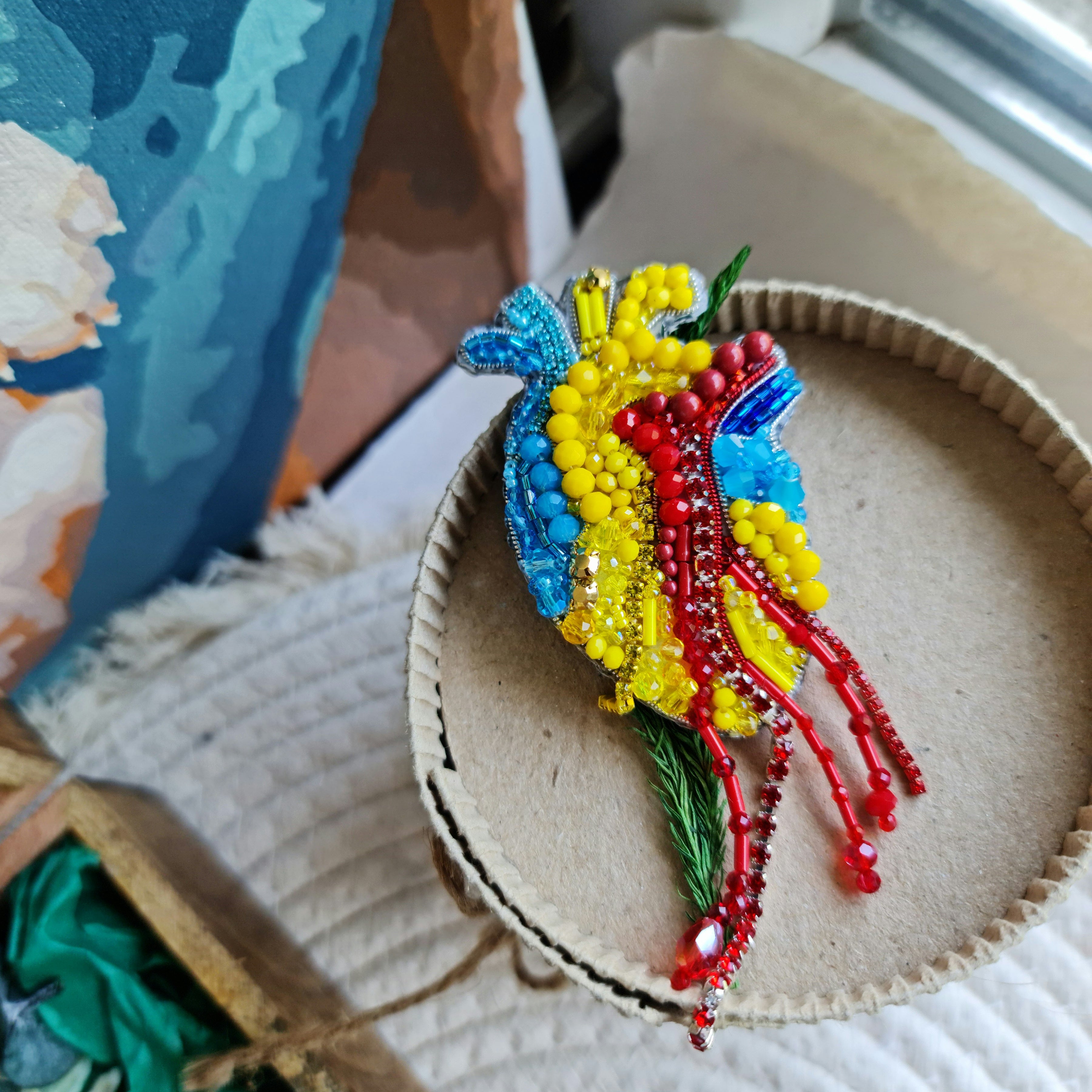 Anatomical heart beaded brooch hand embroidered with blue yellow and red beads, crystals, and sparkling chain details