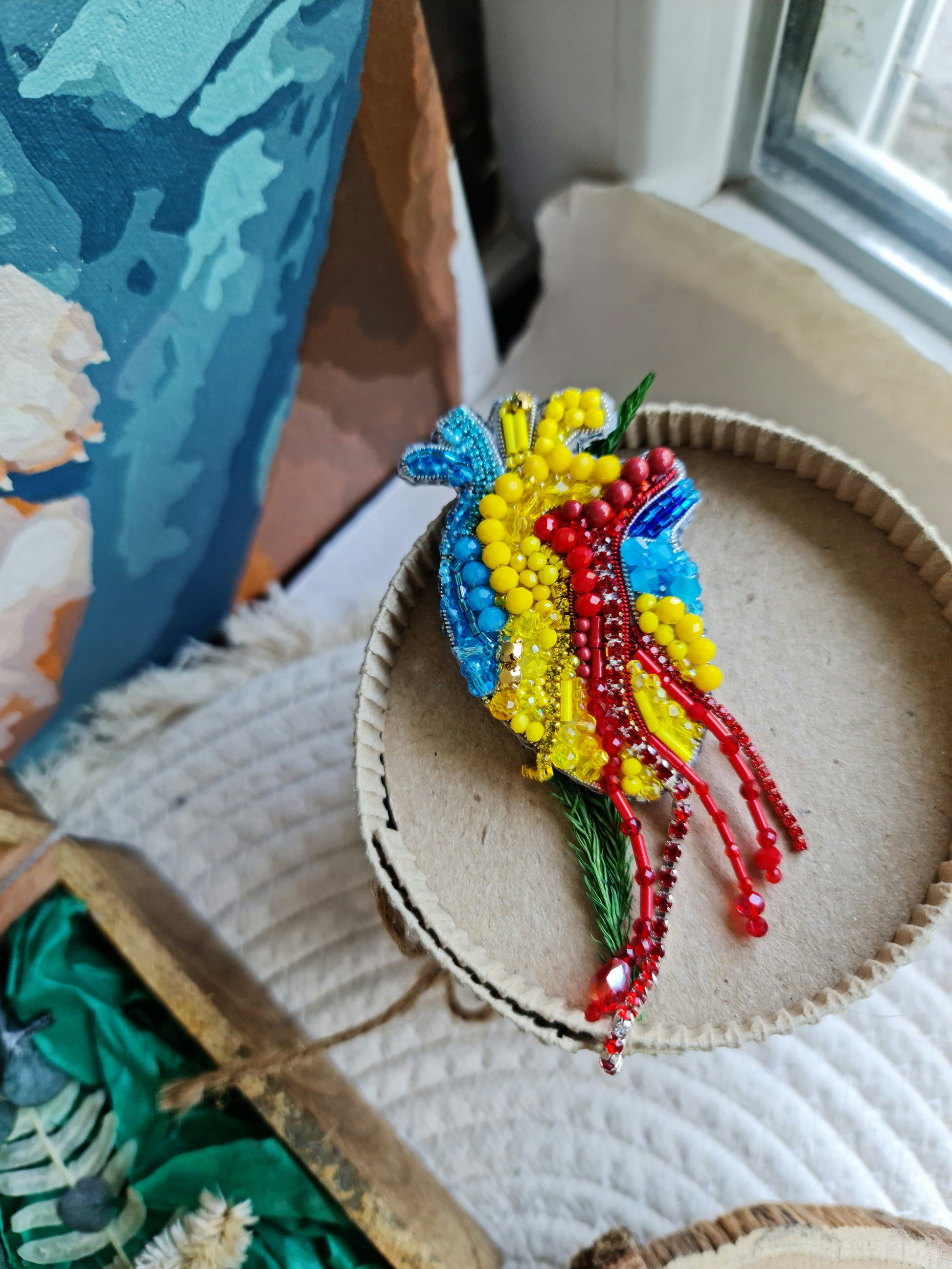 Anatomical heart beaded brooch hand embroidered with blue yellow and red beads, crystals, and sparkling chain details