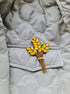 Yellow brooch on a quilted gray jacket