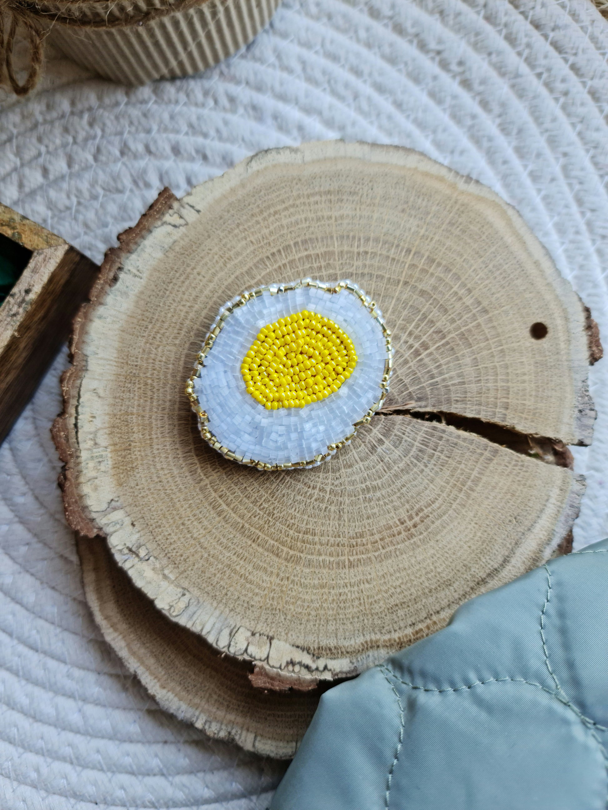 Fried egg beaded brooch hand embroidered with white glass beads, yellow yolk, and gold edge details