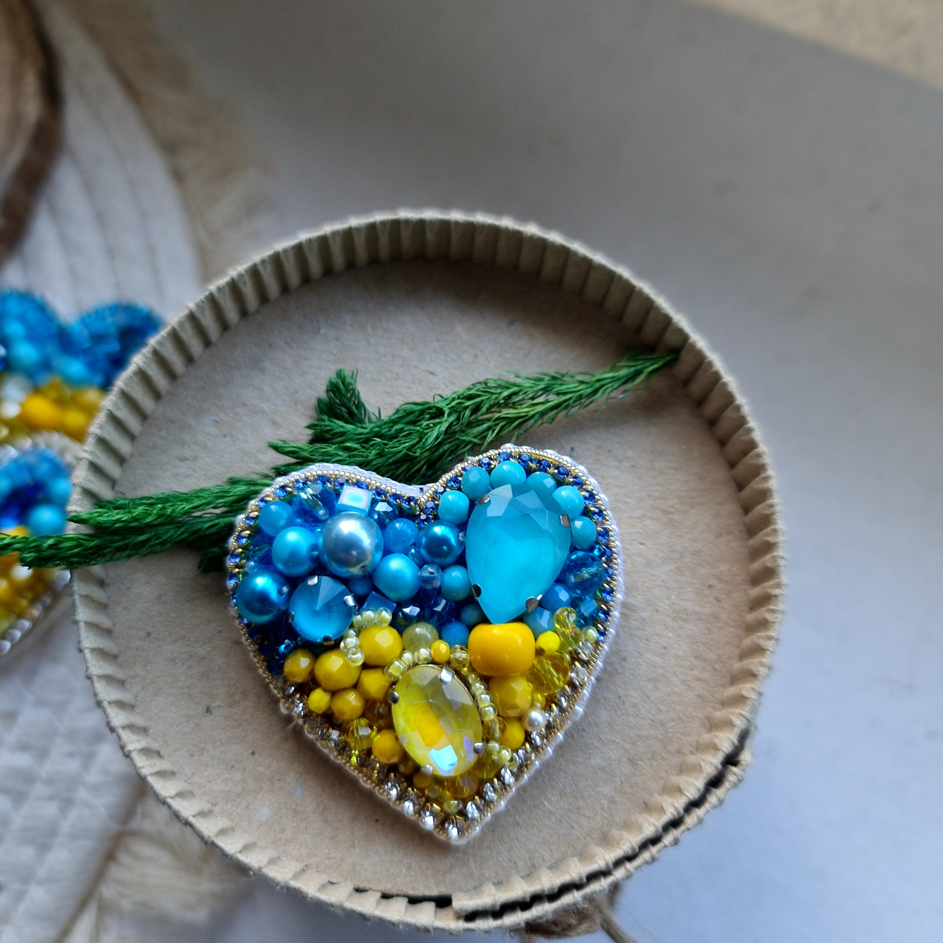 Blue and yellow heart beaded brooch hand embroidered with crystals, pearls, beads, and sparkling Ukraine-inspired details
