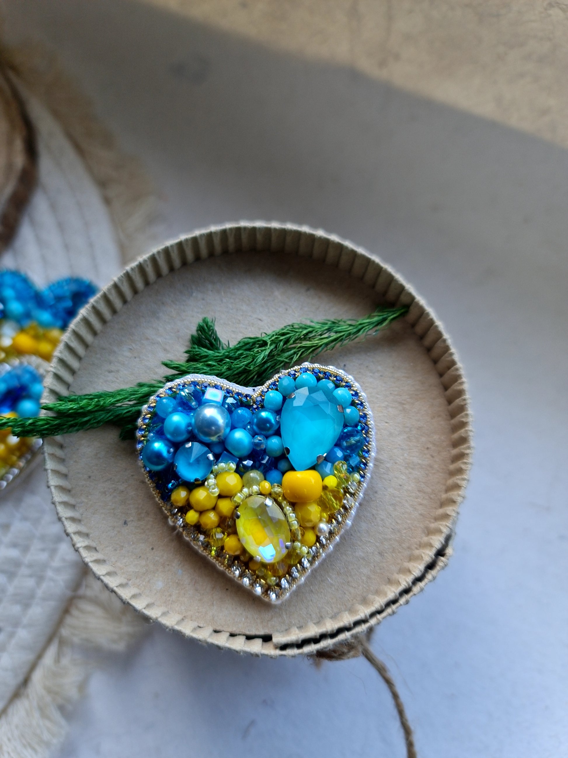 Blue and yellow heart beaded brooch hand embroidered with crystals, pearls, beads, and sparkling Ukraine-inspired details