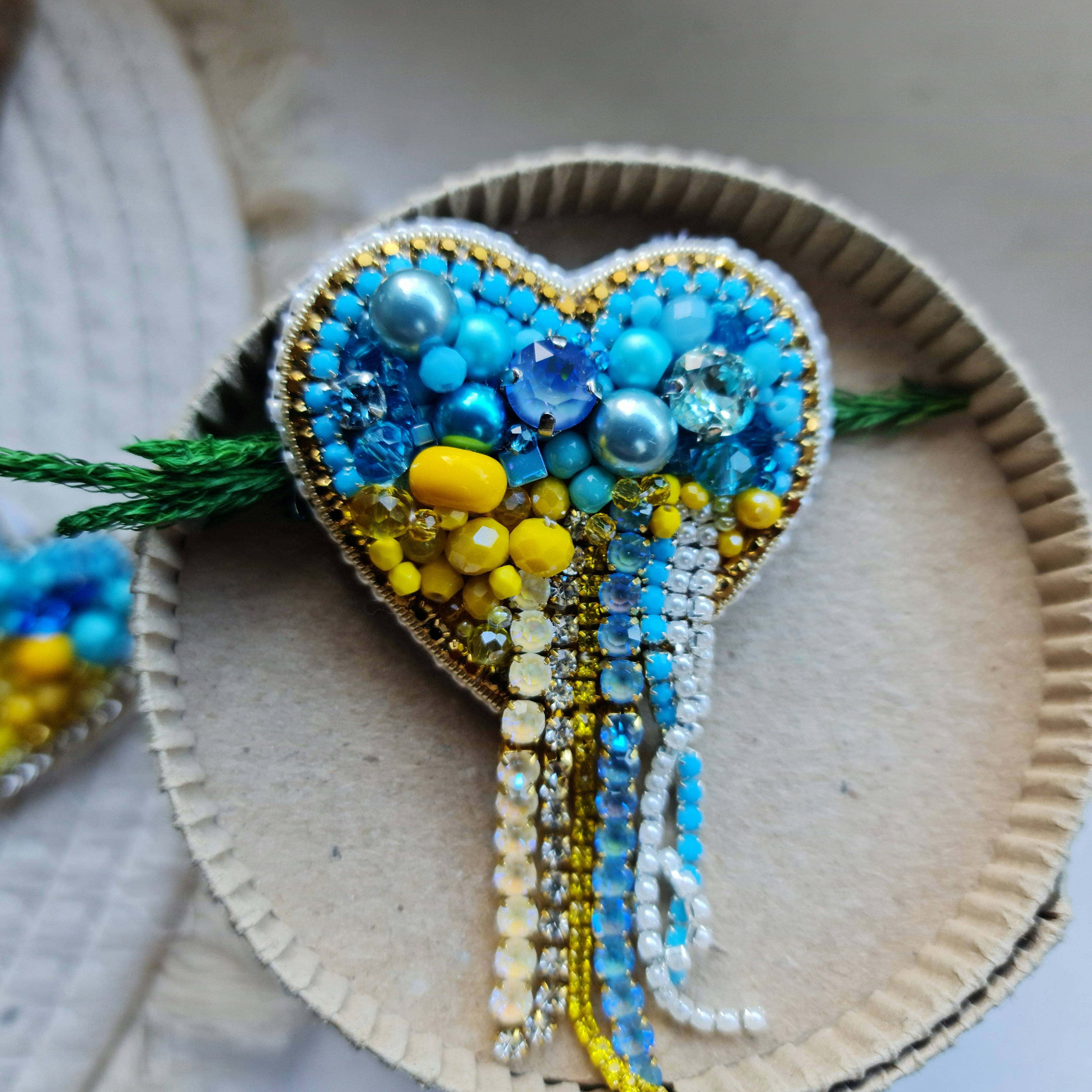 Blue and yellow heart beaded brooch hand embroidered with crystals, pearls, beads, and sparkling Ukraine-inspired details