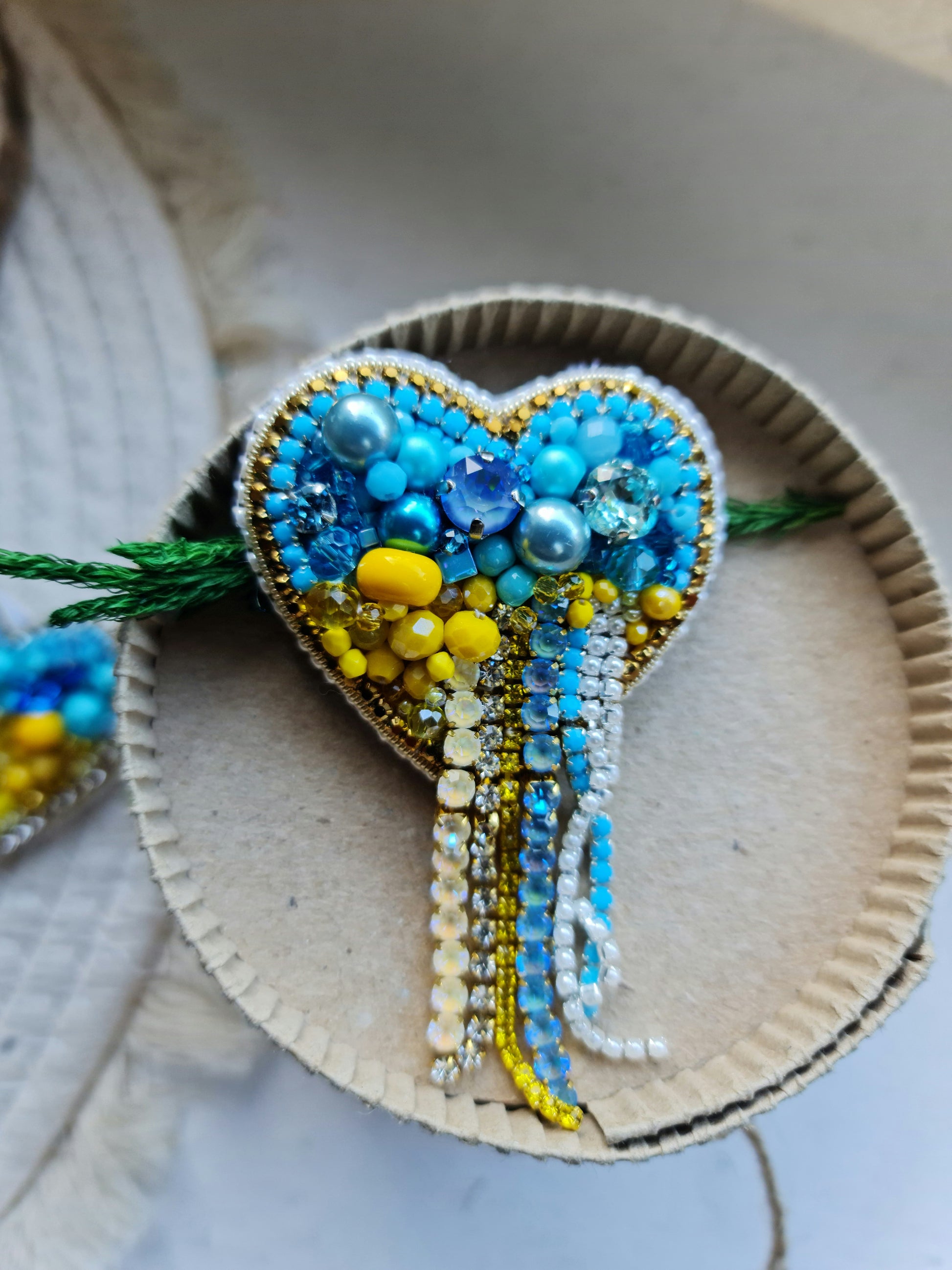 Blue and yellow heart beaded brooch hand embroidered with crystals, pearls, beads, and sparkling Ukraine-inspired details