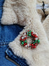 Handmade Christmas wreath brooch embroidered with red, green and white beads, pearls, sequins and crystals, festive holiday pin inspired by traditional Christmas decorations.