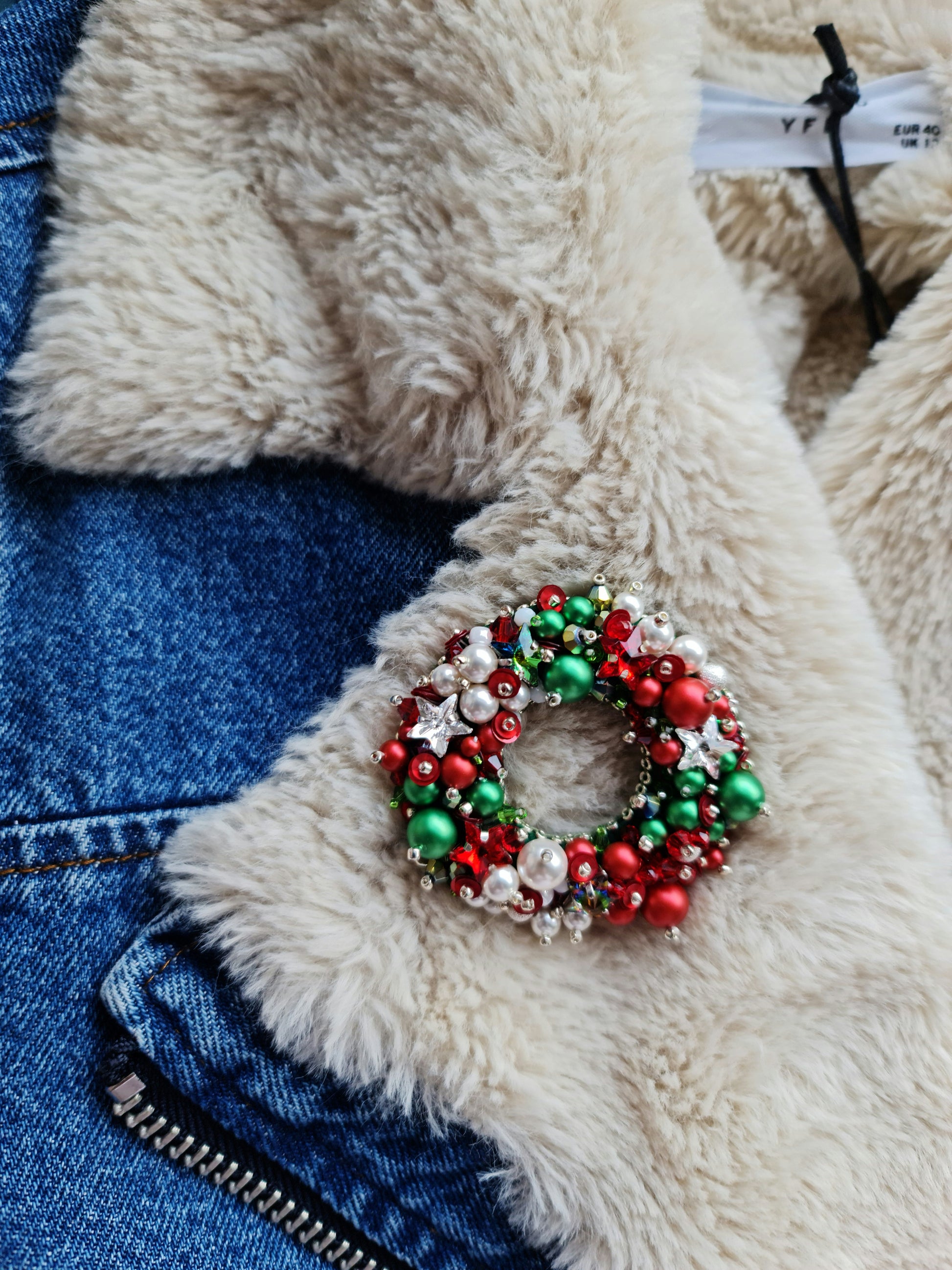 Handmade Christmas wreath brooch embroidered with red, green and white beads, pearls, sequins and crystals, festive holiday pin inspired by traditional Christmas decorations.