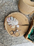 Decorative keychain with leaf and heart designs on a wooden coaster.