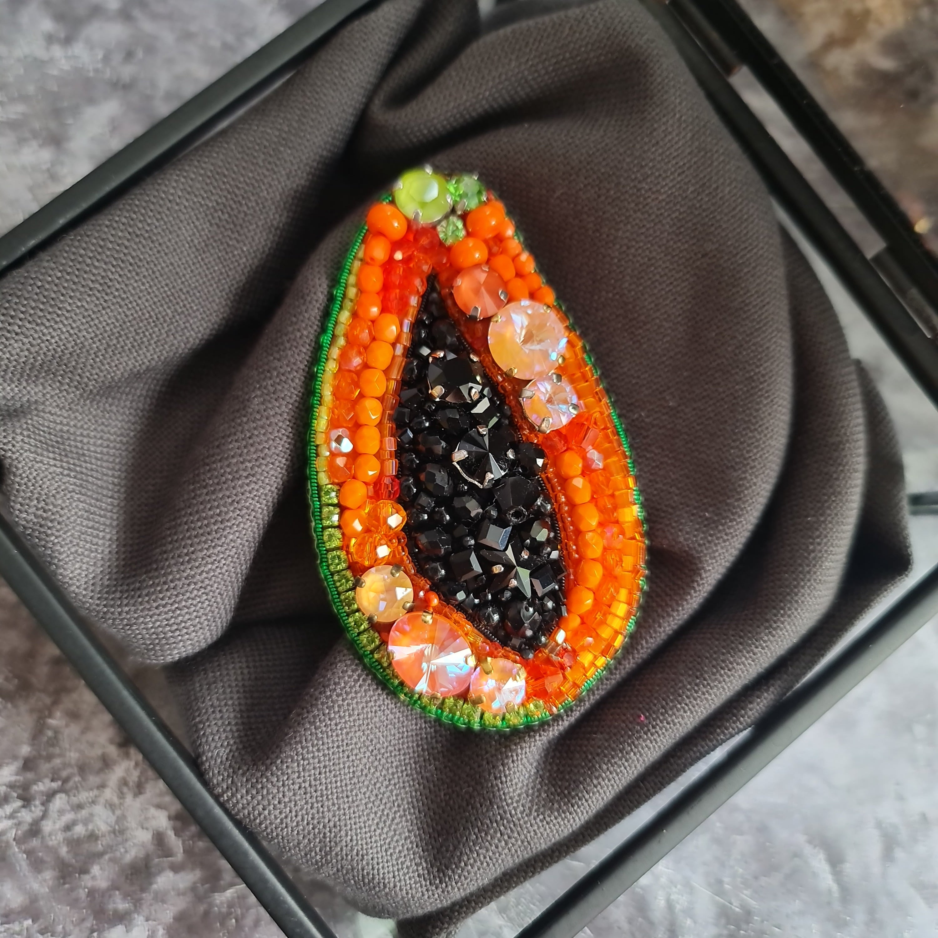 Papaya beaded brooch hand embroidered with orange beads black seed details green edge and sparkling crystals