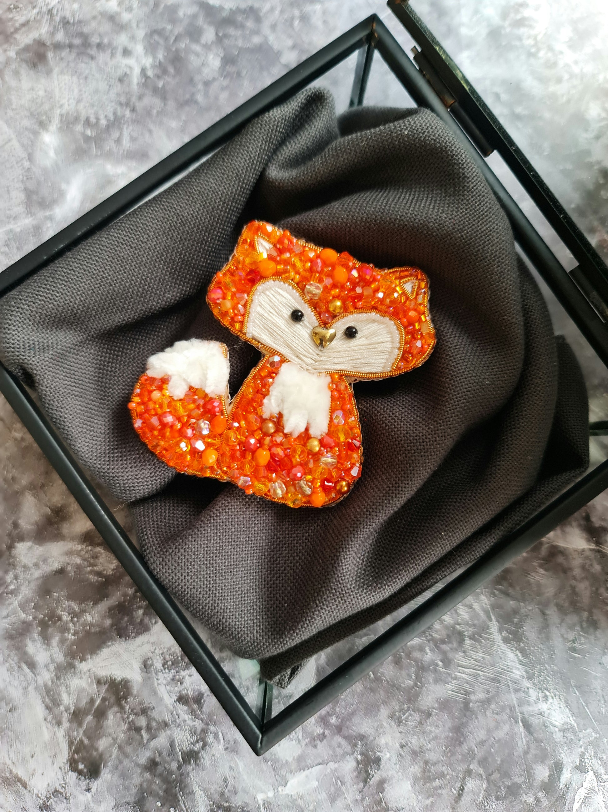 Handmade fox beaded brooch in orange tones with fluffy white tail detail and embroidered face