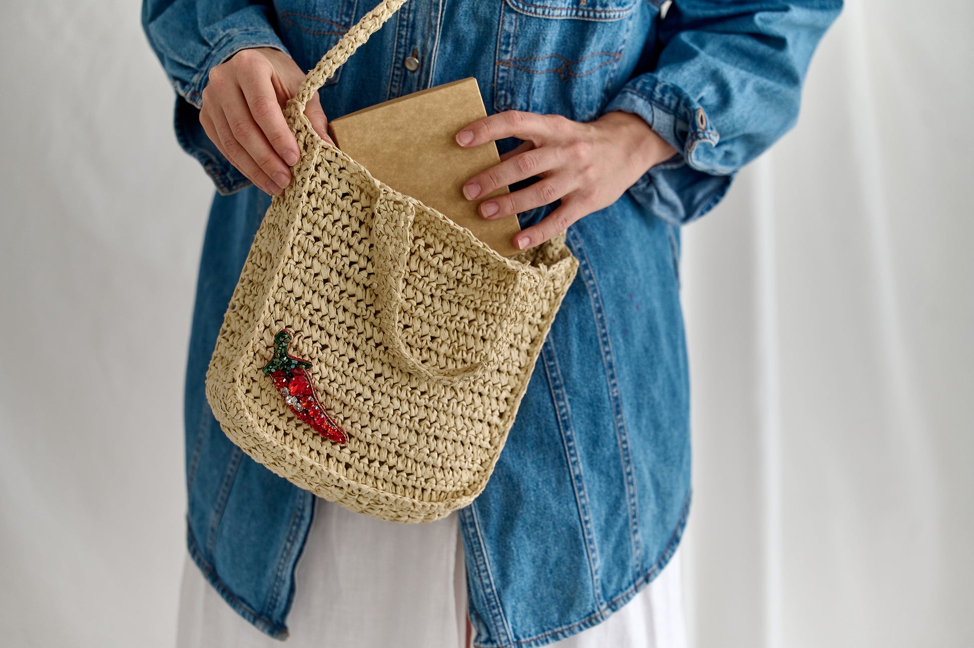 Chili pepper beaded brooch hand embroidered with red crystals green beads and sparkling details on straw bag
