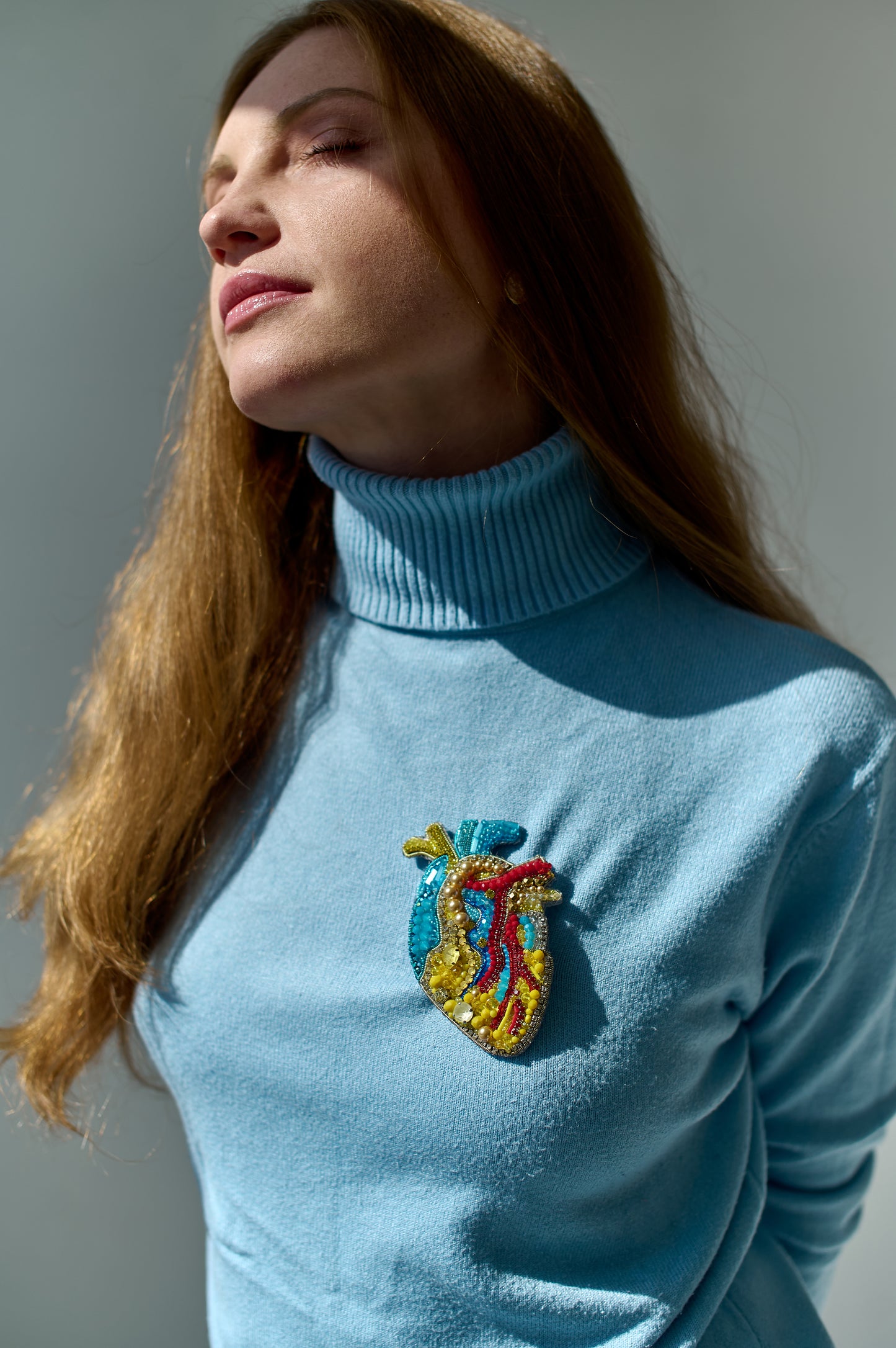 Model wearing the Anatomical Heart Embroidered Brooch pinned on a jacket, highlighting its artistic design and craftsmanship
